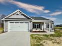 Charming one-story home with a spacious two-car garage, landscaped front yard, and inviting entryway at 144 Emerson Fields Dr, Pikeville, NC 27863