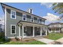 Beautiful two-story home with a covered front porch and lush green lawn at 210 Colvard Farms Rd, Durham, NC 27713