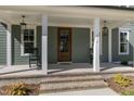 Inviting front porch with rocking chairs and stylish light fixtures at 210 Colvard Farms Rd, Durham, NC 27713