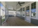 Spacious wooden porch with ceiling fans, white railing, and a view of the neighborhood at 210 Colvard Farms Rd, Durham, NC 27713