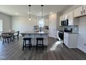 A modern eat-in kitchen features stainless steel appliances, granite countertops, and an island with barstool seating at 370 E Clydes Point Way, Wendell, NC 27591