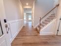 Hallway featuring hardwood flooring, wainscoting detail, and a carpeted staircase leading upstairs at 439 Duncan Creek Rd # 140, Lillington, NC 27546