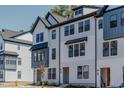 Charming three-story townhome featuring Hardie siding, black window accents, and an inviting entryway at 6408 Tanner Oak Ln, Raleigh, NC 27613