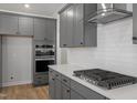Contemporary kitchen with stainless steel appliances, gray cabinets, and a stylish range hood at 130 Bold Dr, Youngsville, NC 27596