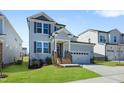 Beautiful two-story home with a gray exterior, complemented by well-manicured lawn and a two-car garage at 413 Edison Rail Ln, Knightdale, NC 27545