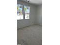 An unfinished bedroom features bright natural light from large windows overlooking the wooded neighborhood at 103 Slocum Dr, Wendell, NC 27591