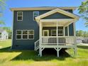 This home features a covered porch with a ceiling fan overlooking a spacious backyard at 196 Grand Griffon Way, Lillington, NC 27546