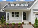 Inviting front porch with classic columns, stone accents, and professionally landscaped garden at 414 S Cross St, Youngsville, NC 27596