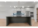 Spacious kitchen with a large dark island, modern appliances and custom backsplash at 414 S Cross St, Youngsville, NC 27596