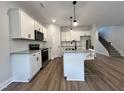 Spacious kitchen with white cabinets, granite countertops, island seating, and stainless steel appliances at 152 S Mistflower St, Clayton, NC 27520