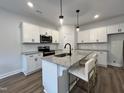 Modern kitchen boasts white cabinets, granite countertops, and a stylish island with pendant lighting at 152 S Mistflower St, Clayton, NC 27520