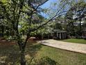 Charming brick home featuring a well-maintained lawn, mature dogwood, and a paved driveway at 184 Pine E St, Lillington, NC 27546