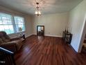 Bright living room with hardwood floors, a cozy chair, and a large window at 184 Pine E St, Lillington, NC 27546