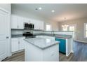 Contemporary kitchen featuring an island with granite countertop, stainless steel appliances, and a view to the dining area at 146 Tupelo Dr, Spring Hope, NC 27882