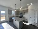 Bright, modern kitchen with granite countertops, stainless appliances, and gray cabinets at 175 W Saltgrass Ln, Smithfield, NC 27577