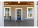 Charming front porch with blue door, neutral siding, and inviting bench at 199 N Smith St, Clayton, NC 27520