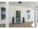 Inviting front porch with a teal door, white columns, and craftsman-style details at 201 N Smith St, Clayton, NC 27520