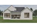 A modern farmhouse-style home with white siding, black roof, outdoor seating, and spacious covered patio at 725 Catawba St, Raleigh, NC 27609