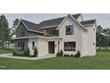 Charming white brick exterior with black trim windows and manicured lawn, enhancing curb appeal and showcasing modern design at 725 Catawba St, Raleigh, NC 27609