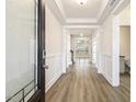 Bright foyer featuring hardwood floors, paneled walls, and views of the living spaces at 73 Jumper St, Wendell, NC 27591
