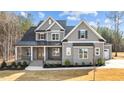 Beautiful two-story home with gray siding, black accents, and a landscaped front yard under a partly cloudy sky at 30 Chestnut Oak Dr, Youngsville, NC 27596