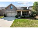 Welcoming home with a well-manicured lawn, lovely front porch, and attached two-car garage at 4110 Argyle Trl, Burlington, NC 27215