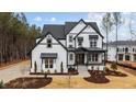 Stunning two-story home showcasing modern farmhouse design with black trim, a covered front porch, and professional landscaping at 45 Chestnut Oak Dr, Youngsville, NC 27596