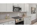 Well-equipped kitchen featuring stainless steel appliances, granite countertops, and stylish backsplash at 22 Van Winkle St, Lillington, NC 27546