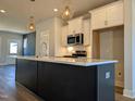 Modern kitchen with a large island, white cabinets, and stainless steel appliances at 908 Allen Park Dr, Raleigh, NC 27604