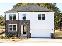 New construction home with white siding, stone accents, attached two-car garage, and landscaped front at 556 Barbour Farm Ln, Four Oaks, NC 27524