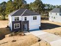 New construction home with white siding, dark stone accents, and attached two-car garage and lawn at 556 Barbour Farm Ln, Four Oaks, NC 27524