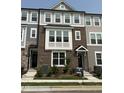 Charming townhome with a brick facade, light gray siding, and well-manicured landscaping at 3010 Freewinds Way # 43, Cary, NC 27519