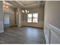 Formal dining room featuring wainscoting, crown molding, modern light fixture, and a large window at 639 Sweet Potato Lane # 3, Nashville, NC 27856