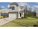 Beautifully landscaped two-story home with a well-maintained lawn, light gray siding, and an attached garage at 82 Gander Dr, Benson, NC 27504