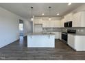 Bright kitchen features white cabinets, granite countertops, stainless steel appliances, and an island at 234 Danube Dr, Zebulon, NC 27597