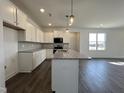Modern kitchen boasts granite countertops, an island with pendant lights, and stainless steel appliances at 234 Danube Dr, Zebulon, NC 27597