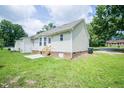 View of backyard features a patio, green grass, and the home's exterior siding at 310 E Horton St, Zebulon, NC 27597