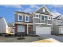 Two-story house with gray siding, white garage door, and landscaping at 26 Steppe Way, Garner, NC 27529