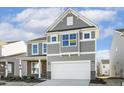 Two-story house with gray siding, white garage door, and landscaping at 26 Steppe Way, Garner, NC 27529