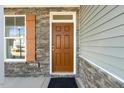 Home features a brown front door with stone accents at 26 Steppe Way, Garner, NC 27529