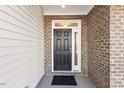 Dark brown front door with sidelights, located on a covered porch at 36 Steppe Way, Garner, NC 27529