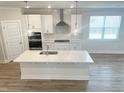 Bright kitchen with a large island, stainless steel appliances, and modern pendant lighting at 428 Fast Pitch Ln, Four Oaks, NC 27524