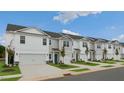 Row of townhouses with attached garages, neat landscaping, and a clear view of the street at 156 Perseus St, Angier, NC 27501