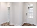 Bright entryway featuring wood floors, a glass-paneled front door, and neutral wall paint at 386 Fast Pitch Ln, Four Oaks, NC 27524