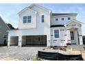 Two-story white home with an open two-car garage and covered entryway at 504 Barbour Farm Ln, Four Oaks, NC 27524