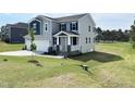 Beautiful two-story home with a well-maintained lawn on a sunny day and a view of a golf course at 576 Barbour Farm Ln, Four Oaks, NC 27524