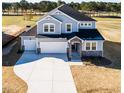 Aerial view of home with a three-car garage and expansive, well-manicured front lawn at 644 Barbour Farm Ln, Four Oaks, NC 27524