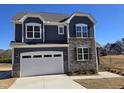 Two-story house with gray siding, stone accents, and a white garage door at 1109 Prominence Dr., Homesite 17, Durham, NC 27712