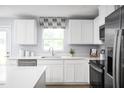 Bright kitchen features white cabinets, stainless steel appliances, and a modern aesthetic at 1573 Ivy Meadow Ln, Zebulon, NC 27597