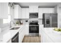 Stylish kitchen boasting quartz countertops, stainless steel appliances, and modern white cabinetry at 1573 Ivy Meadow Ln, Zebulon, NC 27597